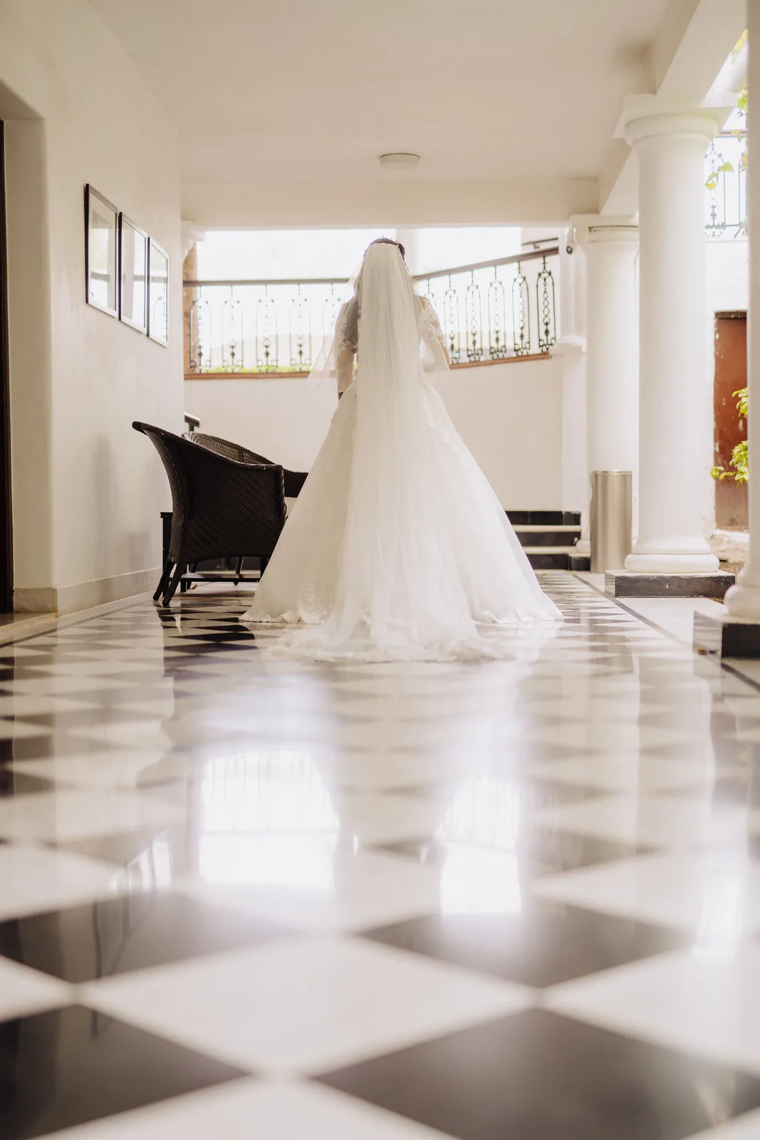 Bride in a white gown in a chequered marble hall with a grand piano